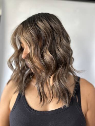 Layered hairstyle with soft waves, highlights, and balayage